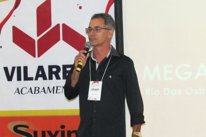 Speaker presenting in front of a co-branded Vilarejo and Suvinil backdrop